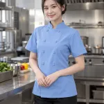 Áo bếp đồng phục màu xanh dương nhạt, nút bọc đồng màu, form tay ngắn thoáng nhẹ, chất vải chéo ít nhăn
