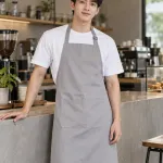Tạp dề đồng phục màu ghi sáng, túi đôi phía trước, form dài đeo cổ, chất kaki cotton
